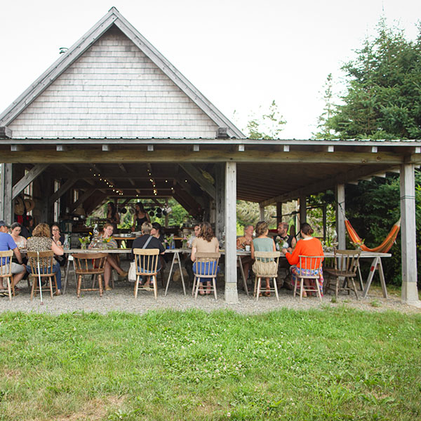 People sitting at dinner under a barn roof